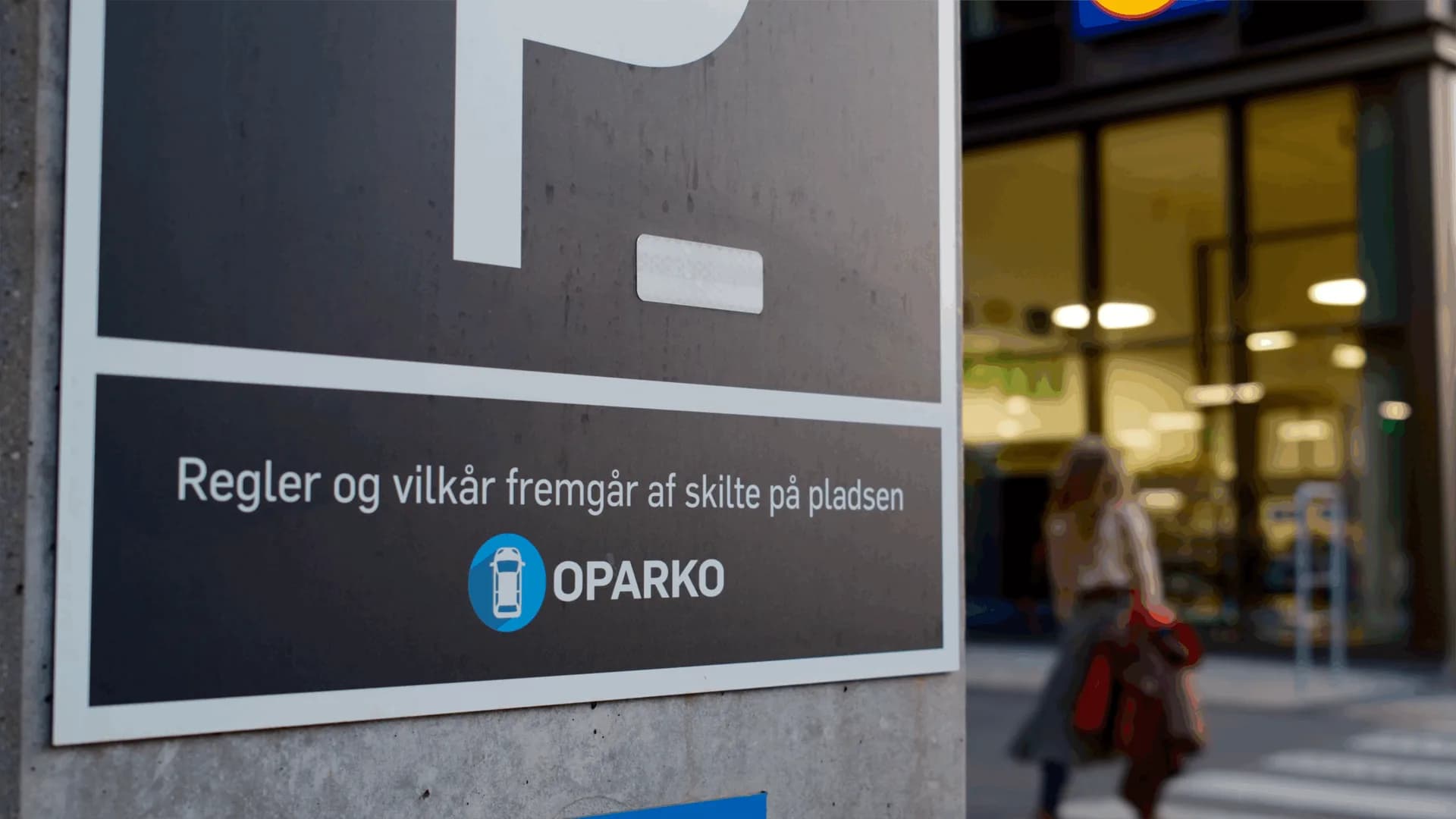 Entréskilt fra OPARKO med teksten: Regler og vilkår fremgår af skilte på pladsen