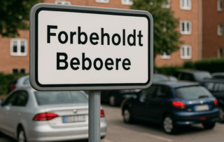 Skilt med teksten “Forbeholdt beboere” foran en parkeringsplads med parkerede biler og røde murstensbygninger i baggrunden.